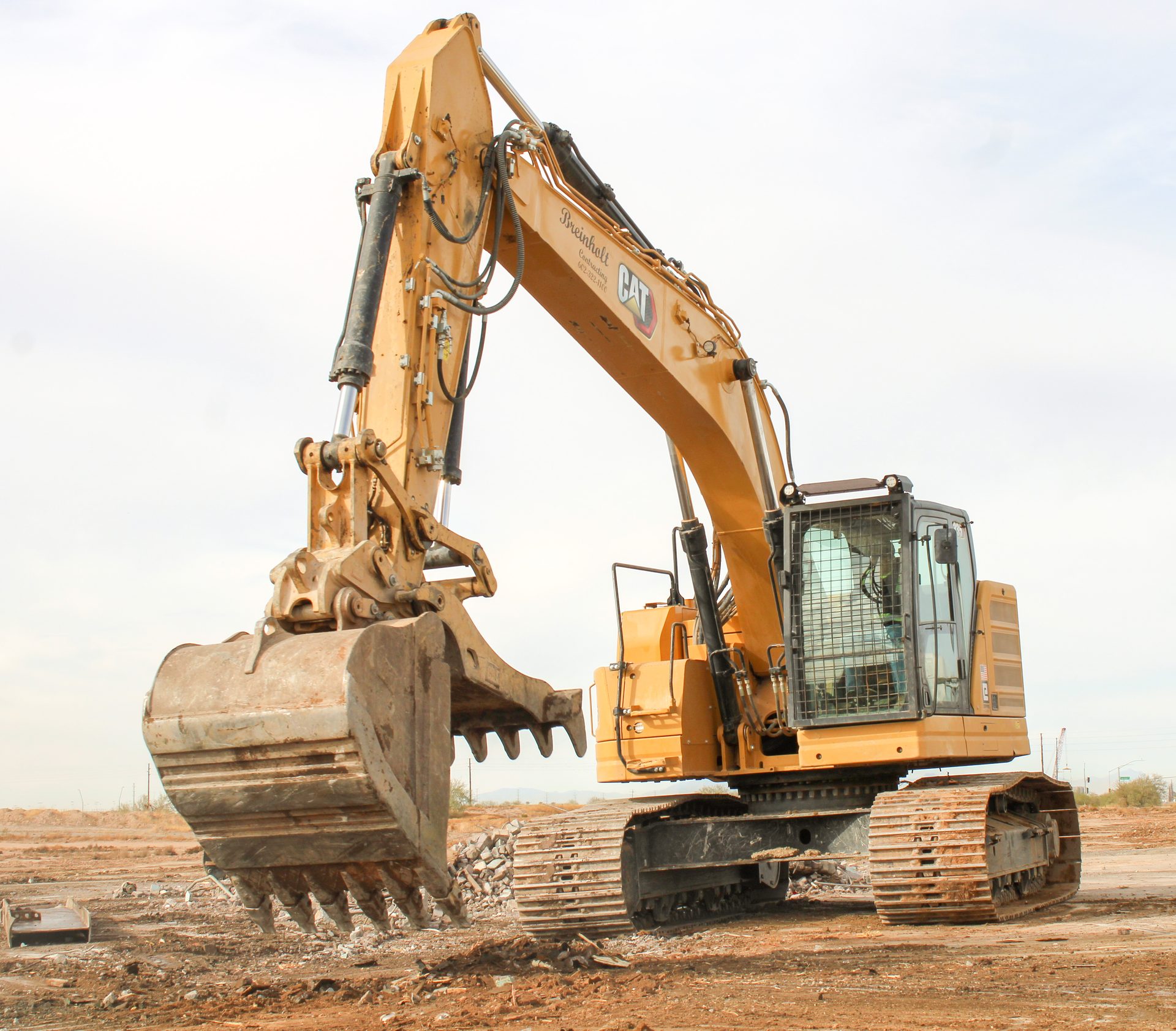 CAT excavator with a sorting grapple clearing demolition debris